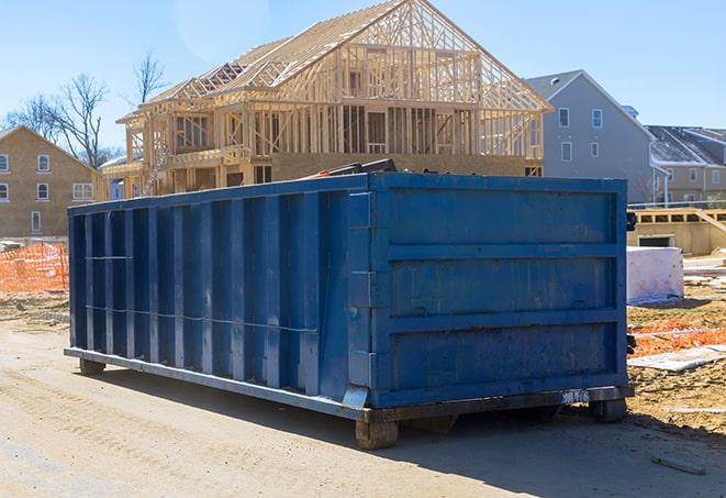 a row of residential dumpsters outside a construction zone